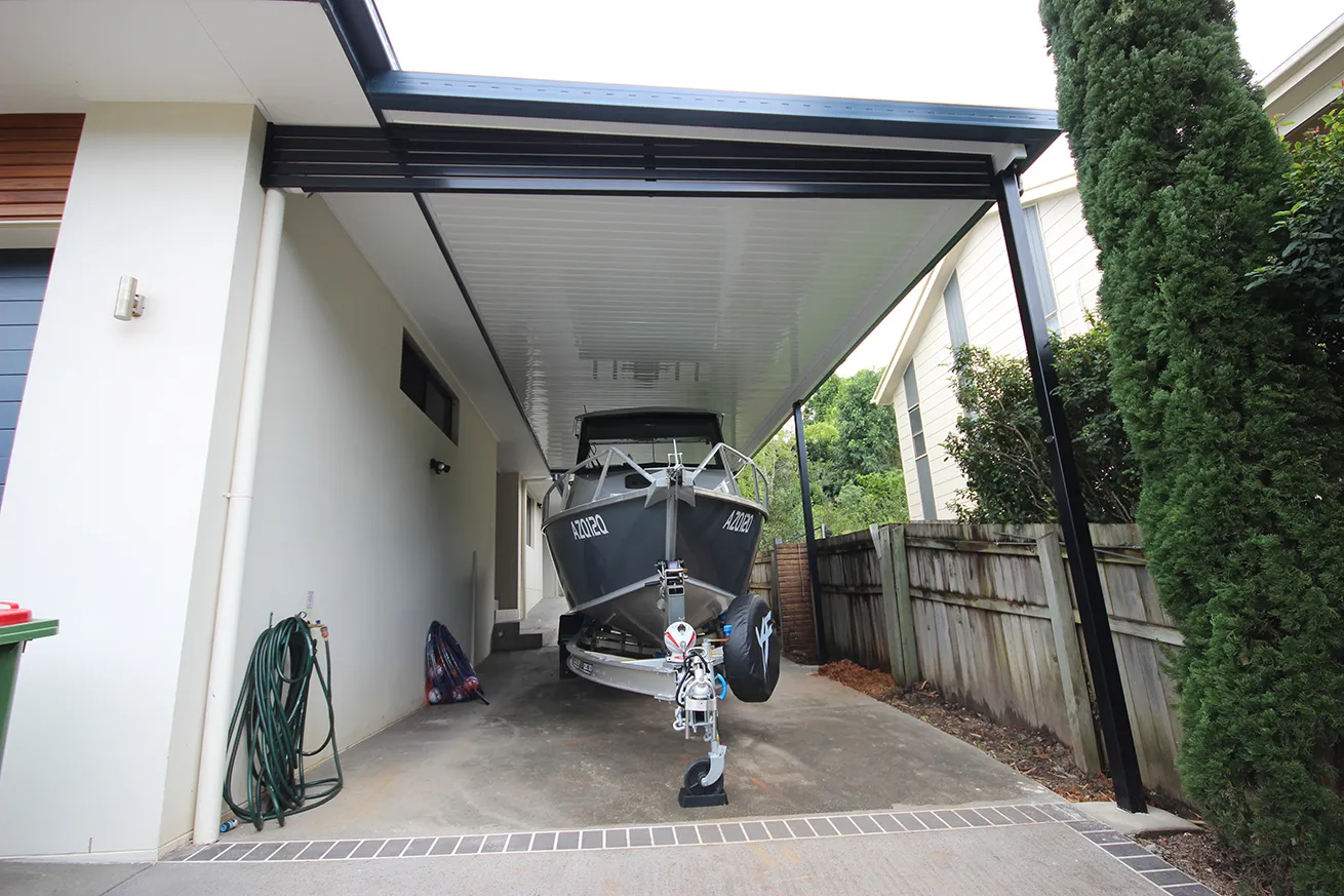 Boat on a trailer parked under a custom boat shelter