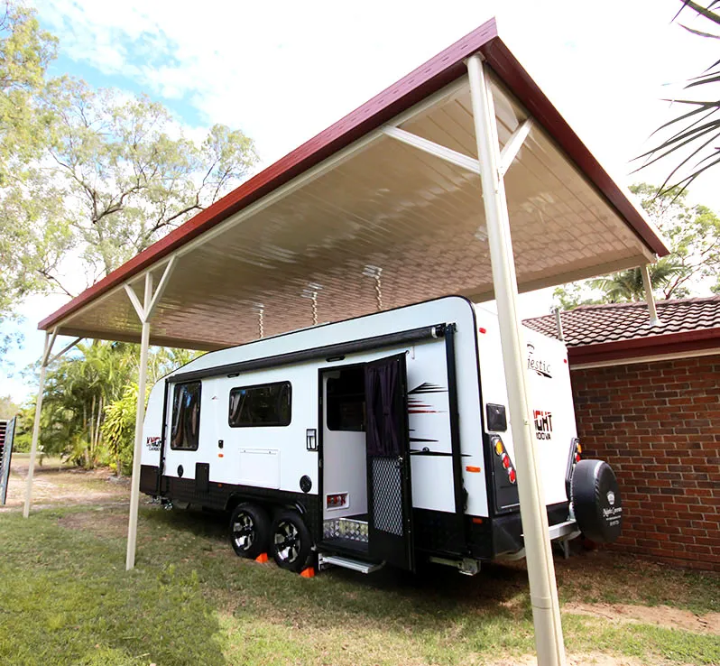 Tall gable shelter covering a caravan beside a house