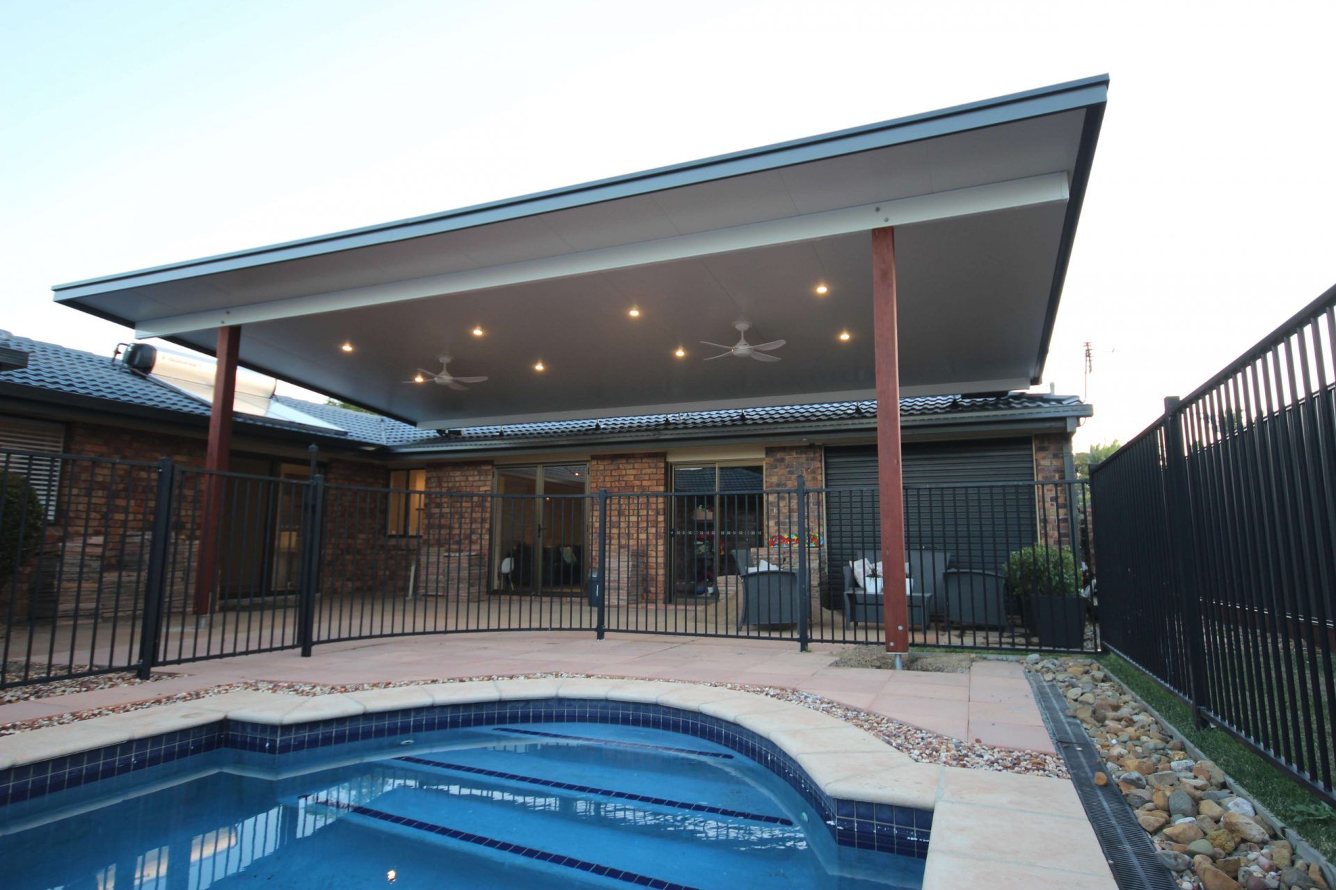 Large insulated patio beside a backyard pool